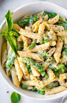 a white bowl filled with pasta and vegetables