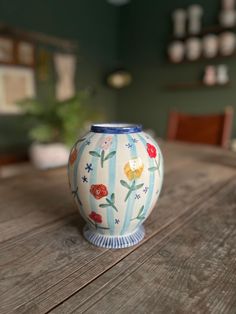 a blue and white vase sitting on top of a wooden table