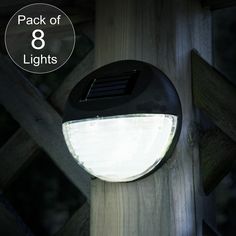 a solar powered light on top of a wooden post with the text pack of 8 lights