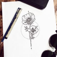 an ink drawing of two flowers on paper next to sunglasses and pen with eyeglasses