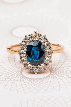 a blue diamond ring sitting on top of a table