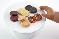 a toy hand reaching for cookies on a plate