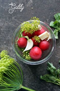 radishes and cheese in a glass bowl on a table with herbs around them