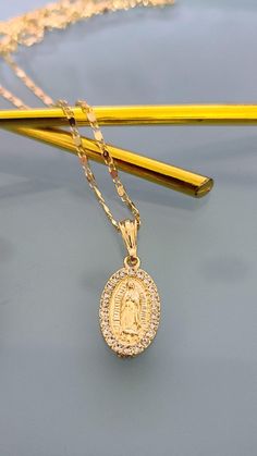 "14k gold plated Virgin Mary (Guadalupe Virgin) Pendant with Necklace. Special Mother's Day, Father's Day, Valentine's Day, Easter, Christmas, or any holiday! Gorgeous Virgen de Guadalupe pendant *Pendant Height: 1.25\" inches *Pendant Width: 0.5\" inch *14k Gold Plated Material: Copper *Include 3 sizes Valentine chain - 24\" inches, 22' inches and 18\" inches Measurements: Chain - 12 inch. from top to bottom (24\" Long from end to end) Measurements: Chain - 11 inch. from top to bottom (22\" Lon Virgencita Gold Necklace, Mexican Gold Jewelry Necklaces, Mexican Jewelry Gold Pendant Necklace, Virgen Mary Necklace, Gold Necklace Virgin Mary, Catholic Necklace Gold, Virgin Mary Chain, Gold Mexican Necklace, Mexican Necklace Gold