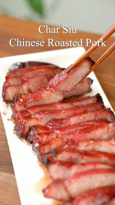 chopsticks sticking out of the top of some meat on a square white plate