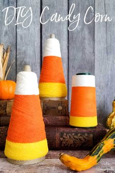 three cones are sitting on top of some books and pumpkins in front of them