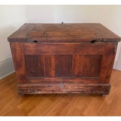 an old wooden chest sitting on top of a hard wood floor