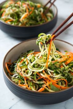 a bowl filled with broccoli, carrots and sprouts on top of a table