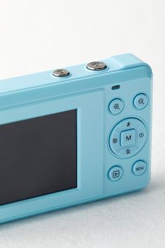 a blue digital camera sitting on top of a white surface