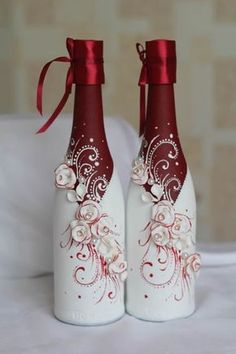 two wine bottles decorated with red and white designs