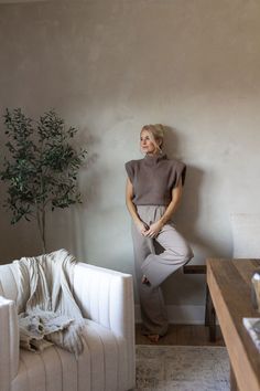 a woman leaning against the wall in her living room