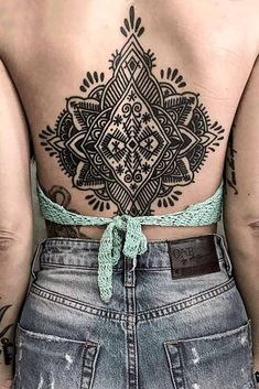 the back of a woman's body with tattoos on it