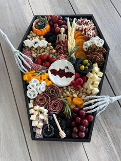 a tray filled with different types of food on top of a wooden table next to utensils