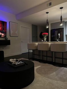 a living room filled with lots of furniture next to a flat screen tv mounted on the wall