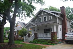 a car is parked in front of a house with white trim and windows on the second story