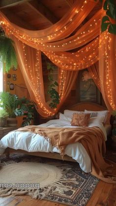 a bed covered in orange drapes and lights