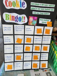 a sign that says cookie bingo with orange sticky notes on it and some candy in the background