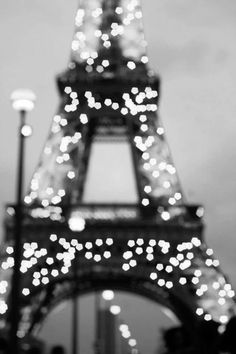 the eiffel tower in black and white is lit up with lights on it