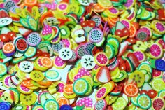 many different colored buttons with fruit designs on them and some are cut in half to look like fruits