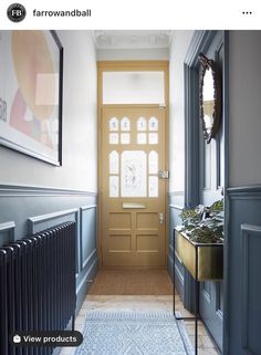 an entryway with a blue rug and yellow door on the right side, and a gold radiator to the left