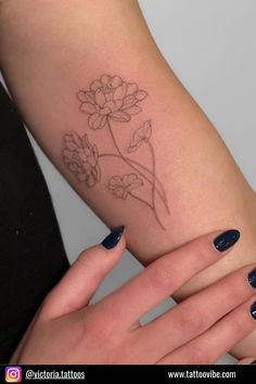 a woman's arm with a flower tattoo on the left side of her arm