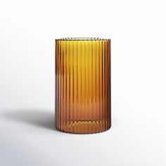 an orange glass vase sitting on top of a white surface with no one around it