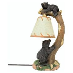 a lamp with a bear sitting on top of it next to a stuffed animal in a tree