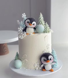 there is a cake with two penguins on it