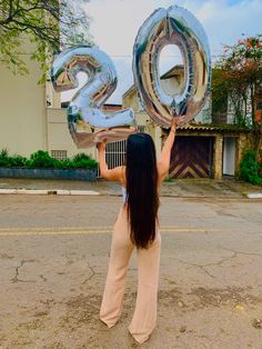 a woman is holding up the numbers in front of her