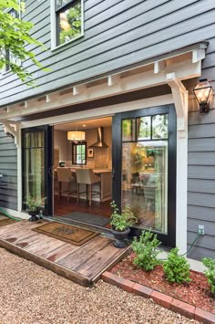 an open patio with wooden steps leading to the back door and dining room in the background