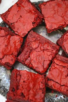 some red food is sitting on a silver plate and it looks like they are made out of brownies