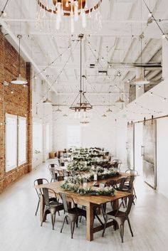 an empty room with wooden tables and chairs, surrounded by greenery on the table