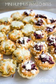 mini hummus phylo bites on a white plate with blueberries and cheese