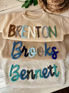 two knit sweaters with the words benton, brooks, and emmett written on them