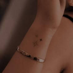 a woman's arm with a small star tattoo on the left side of her wrist