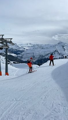 two people on skis standing at the top of a mountain