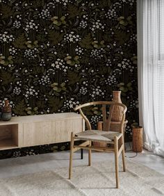 a chair and table in front of a wallpapered room with flowers on it