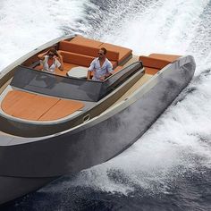 two people riding in a motor boat on the water with an orange seat and brown cushions