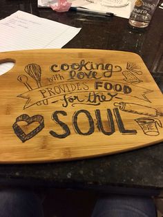 a wooden cutting board with writing on it sitting on top of a black countertop