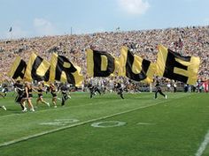 the football team is running on the field with their name signs in front of them