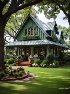 a green house with lots of windows and plants on the front porch is surrounded by trees