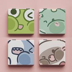 four square coasters with cartoon characters on them, one is green and the other is pink