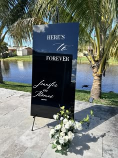 there is a sign that says forever and always with flowers in front of the water