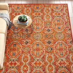 an orange rug in the middle of a living room with a couch and coffee table