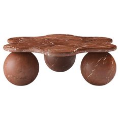 a marble top coffee table with two balls on it's legs and an oval base