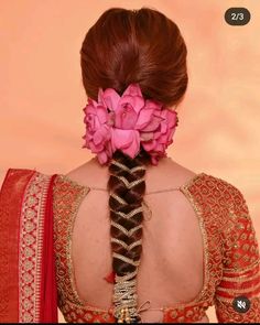 the back of a woman's head with braids and flowers in her hair