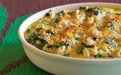 a casserole dish with broccoli and cheese in it on a green place mat