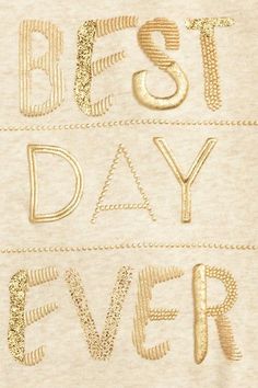 the words best day ever written in gold foil on a beige sweater with sequins