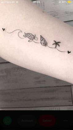 a woman's arm with two turtles and palm trees on the left side of her arm