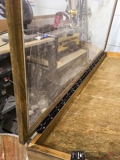 the inside of a glass case is being worked on with wood and other tools in it